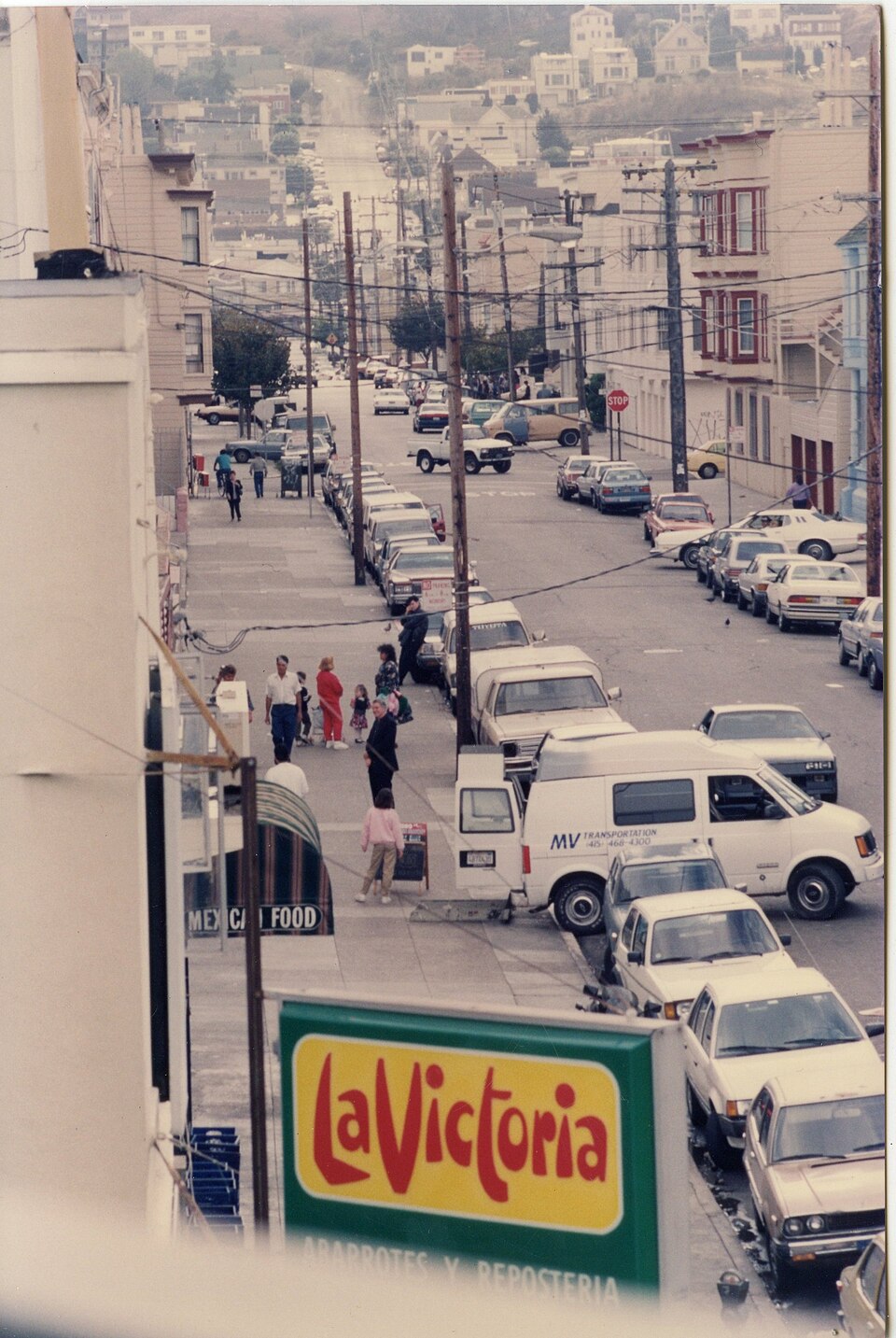 Letrero de La Victoria sobre la Calle 24 y Alabama, visto desde arriba, con las calles de la Misión descendiendo a lo lejos en 1990.