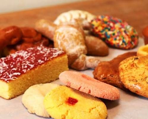 Pasteles y galletas surtidos de La Victoria sobre una mesa de madera.