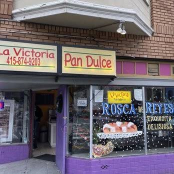 Fachada de La Victoria durante el día con el letrero Pan Dulce y la ventana decorada.